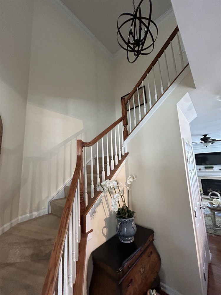Cornelius townhouse staircase before renovation, with carpeted stairs and a dated railing