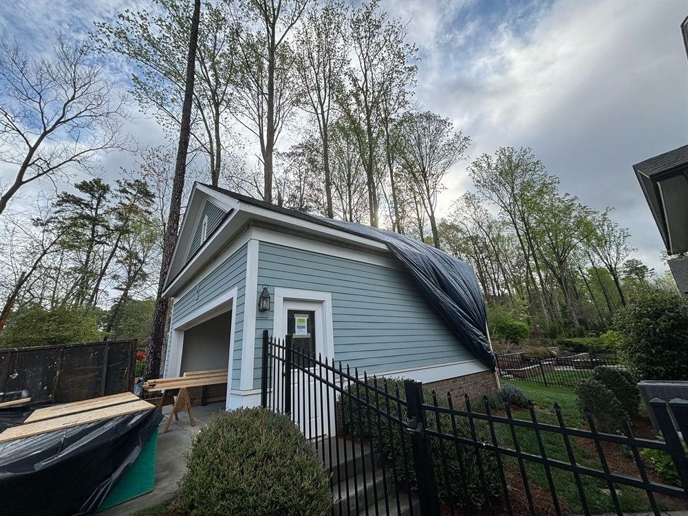 Single-story detached garage in Davidson before the overbuild, with the roof tarped for demolition