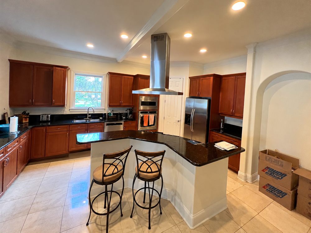 Lake Wylie kitchen before renovation, with cherry cabinets, black granite counters and a tile floor