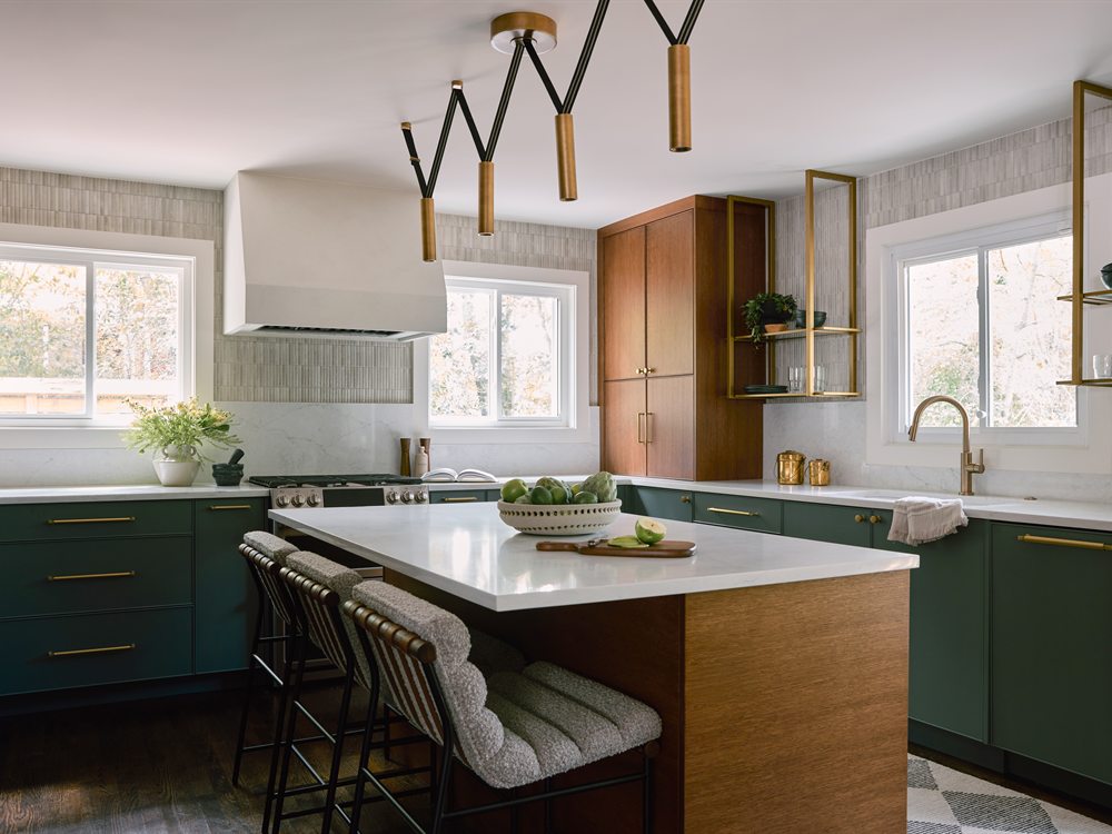 Same Lansdowne kitchen rebuilt by Revival Construction: deep green cabinetry, warm wood island and plaster hood
