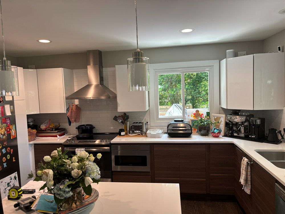 Lansdowne kitchen in Charlotte before renovation: glossy white uppers, dark wood lowers and a stainless chimney hood