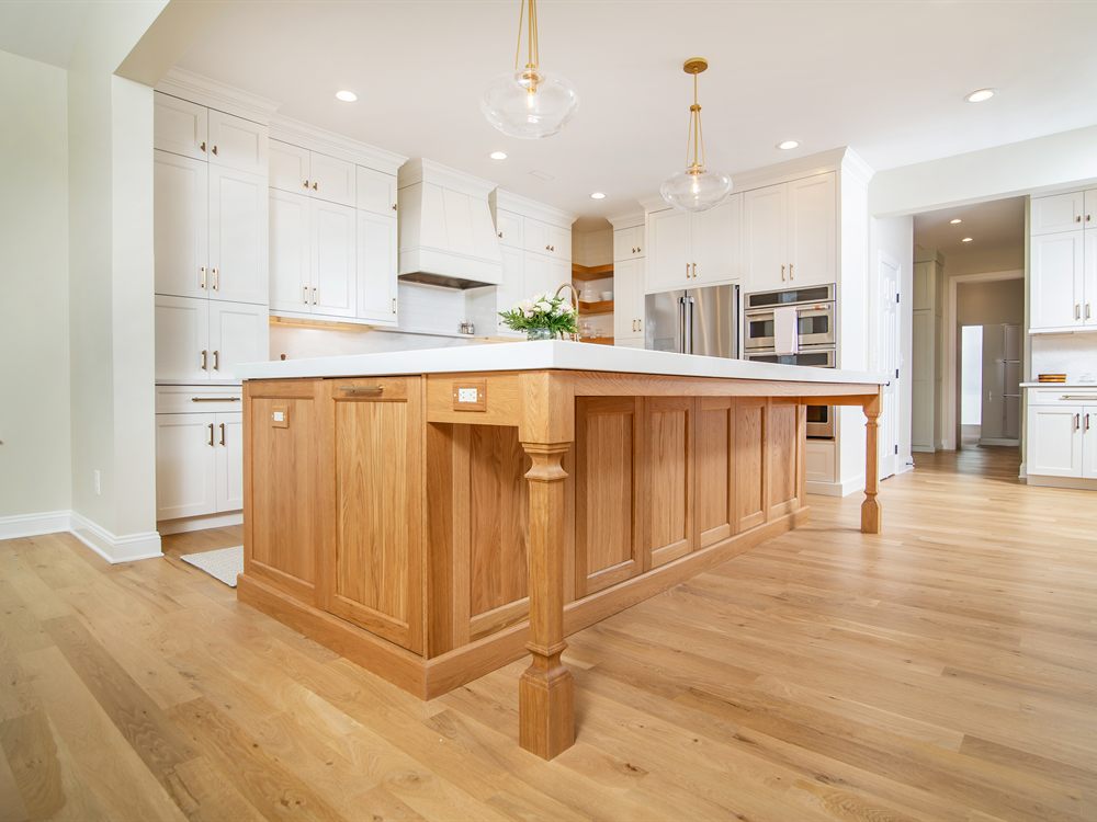 The same Monroe kitchen after renovation by Revival Construction, with white cabinetry and a natural wood island
