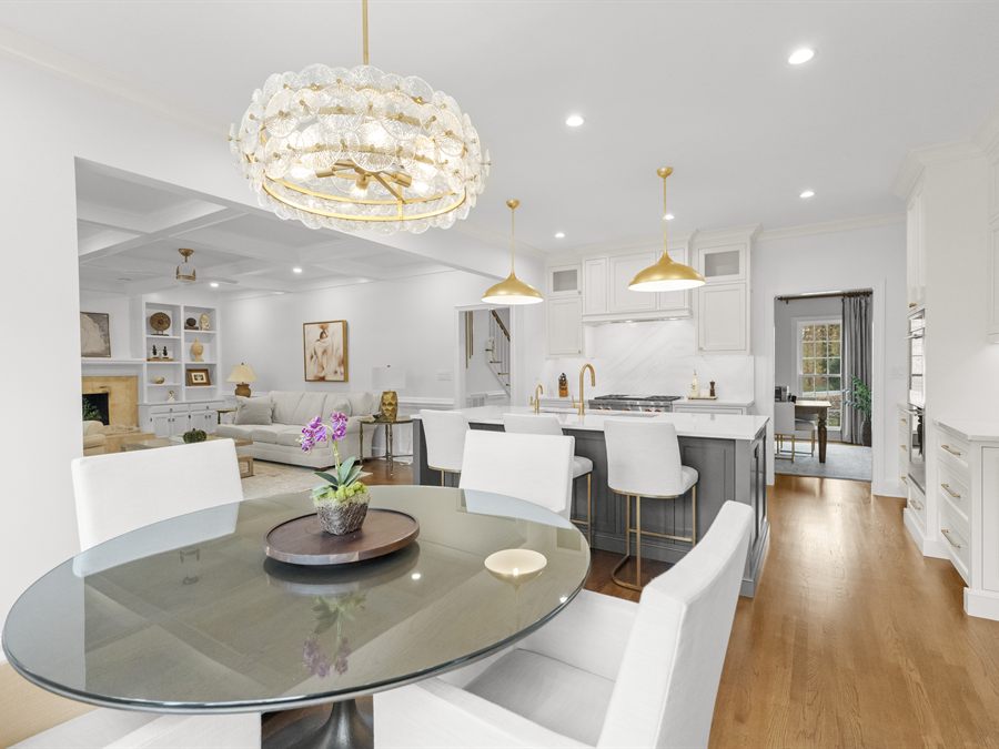 The finished Providence Plantation kitchen and dining area by Revival Construction, with white cabinetry and a crystal chandelier