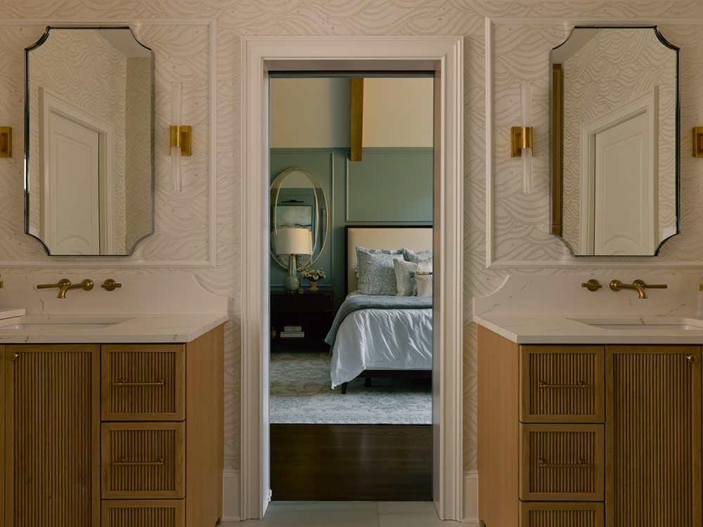 Same primary bath after renovation by Revival Construction: two custom wood vanities with brass faucets, Charlotte