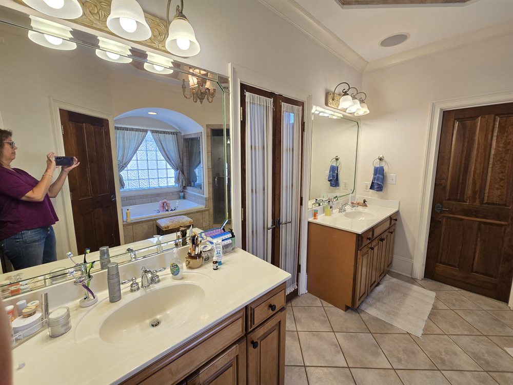Providence Springs primary bath before renovation: cultured marble vanity, globe lights and a corner tub, Charlotte