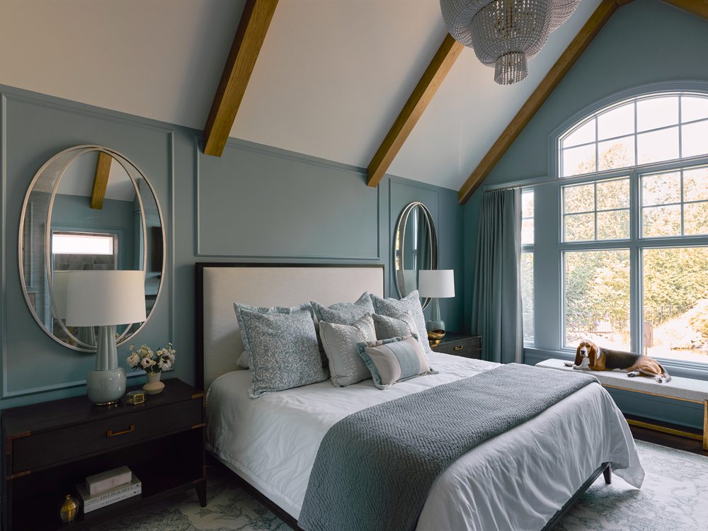 Same primary bedroom after renovation: oak floors, white oak clad beams and blue-gray panel molding, Charlotte