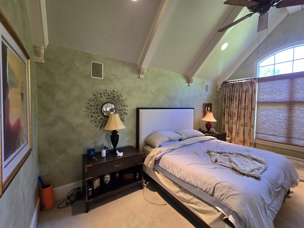 Providence Springs primary bedroom before renovation, with carpet, sponge-painted walls and painted boxed beams