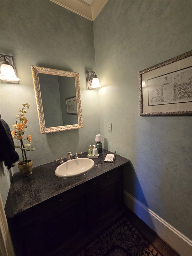 Providence Springs powder bath before renovation, with a dark vanity, gilt mirror and sponge-painted walls