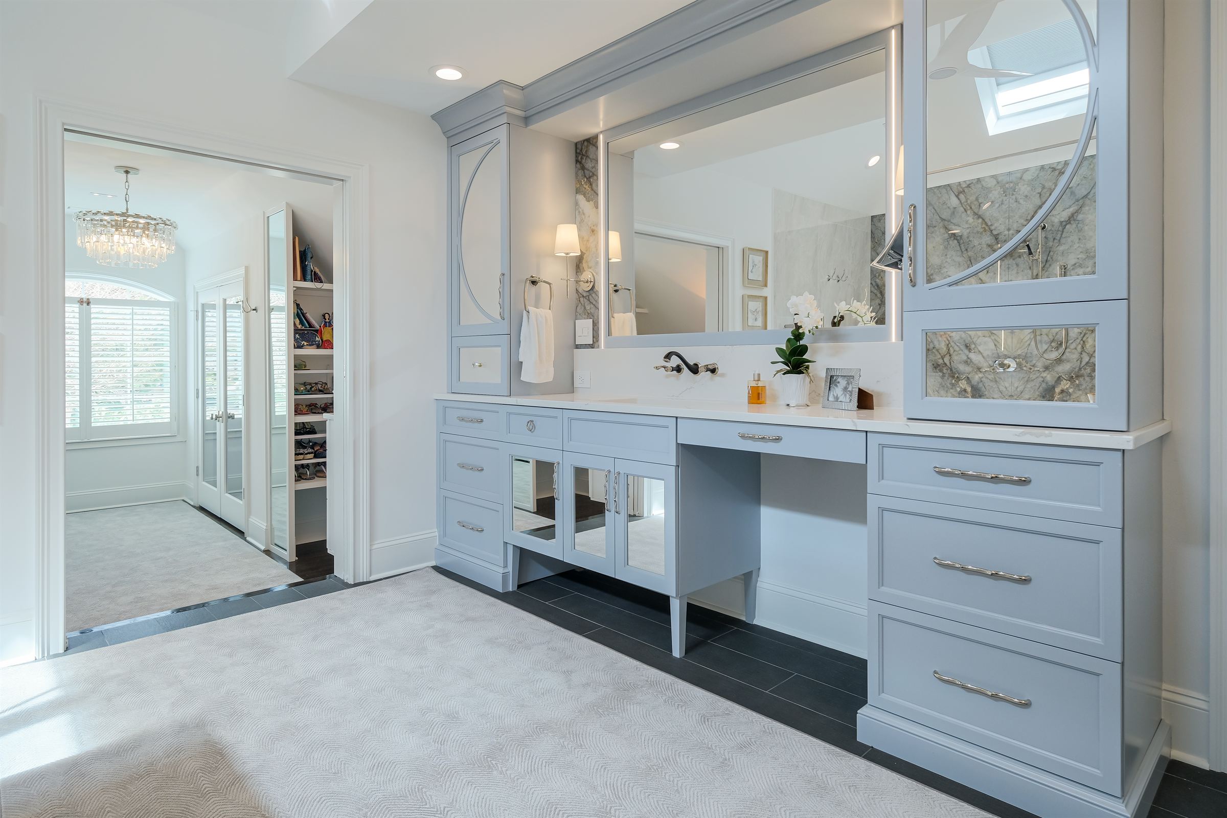 Custom powder-blue vanity wall with mirrored cabinet doors in a Lake Norman primary bath renovation by Revival Construction