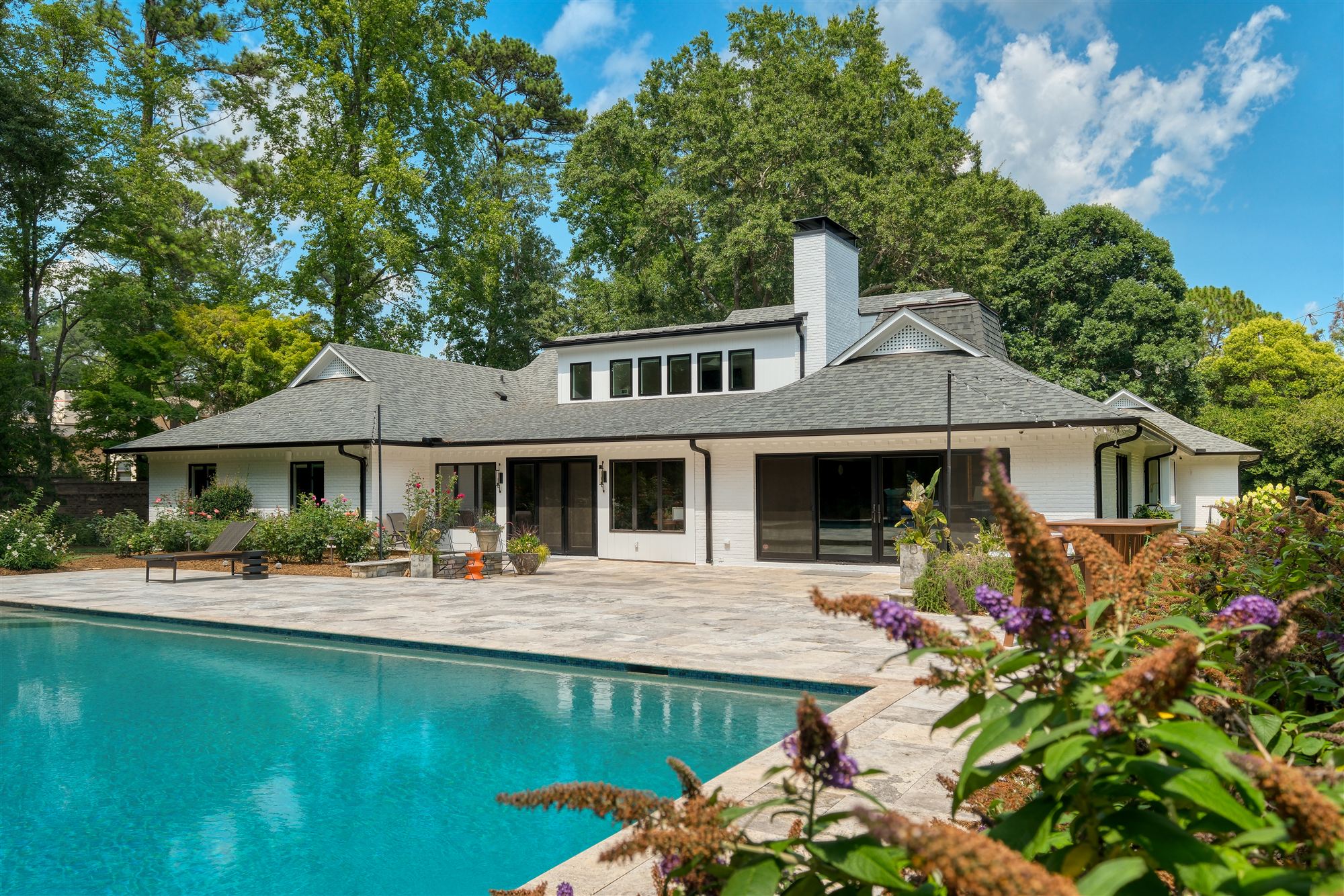 White-brick custom exterior with resort pool, SouthPark, by Revival Construction