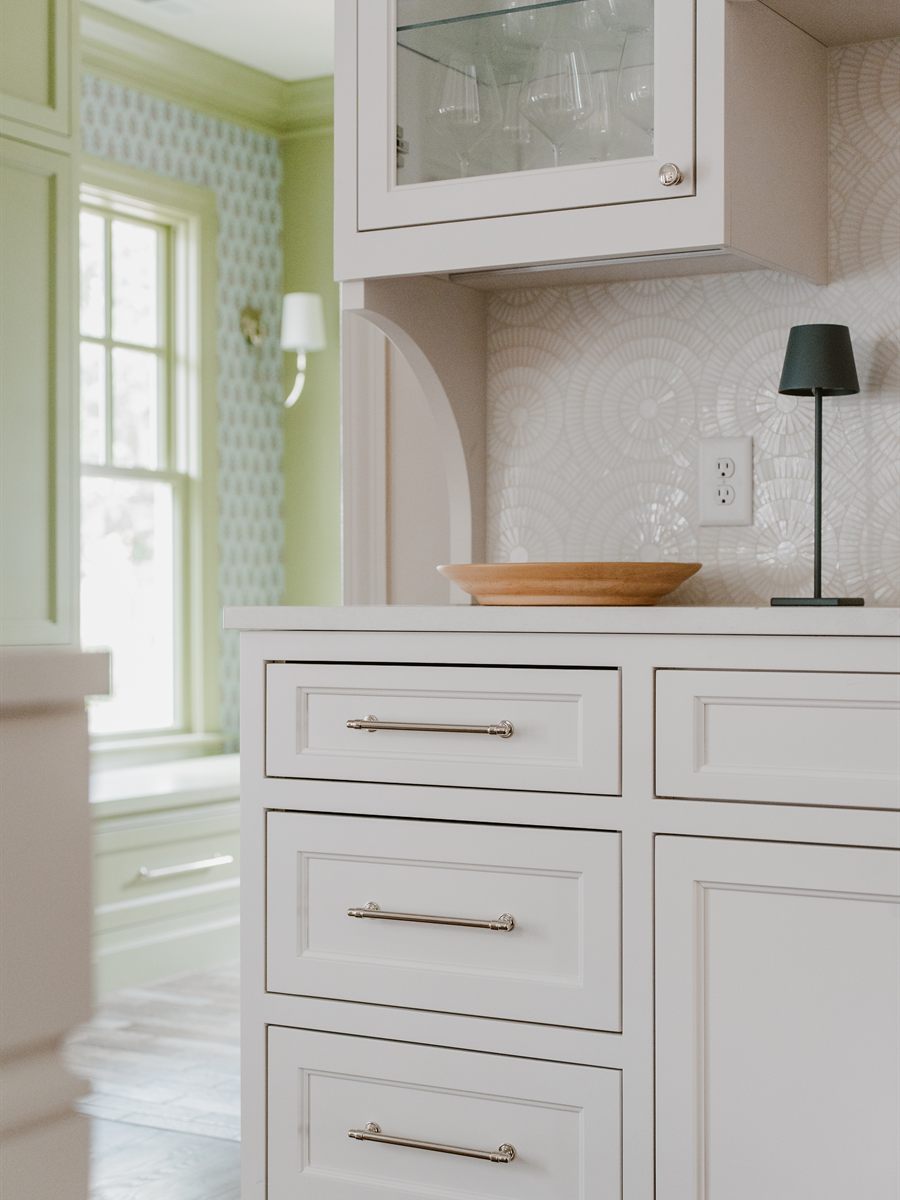 Inset custom cabinetry with polished nickel pulls and a patterned tile backsplash in the MacBain historic renovation by Revival Construction