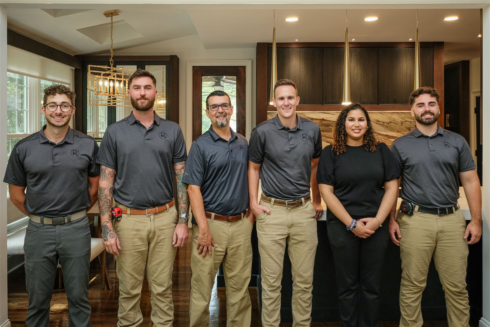 Six members of the Revival Construction team in matching company shirts in a finished kitchen