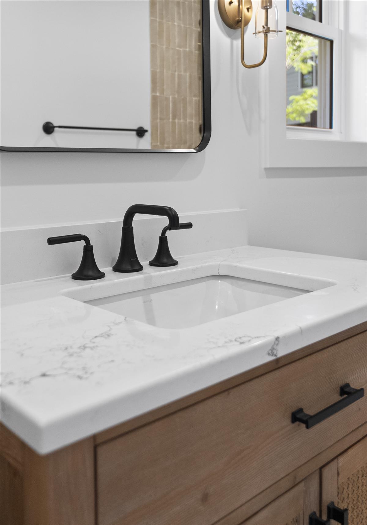 Vanity with a black faucet and white countertop, Charlotte ADU