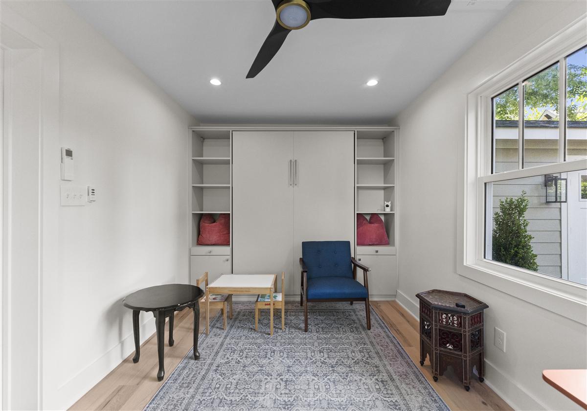 Guest studio sitting area with a blue chair and built-in shelves, Charlotte ADU