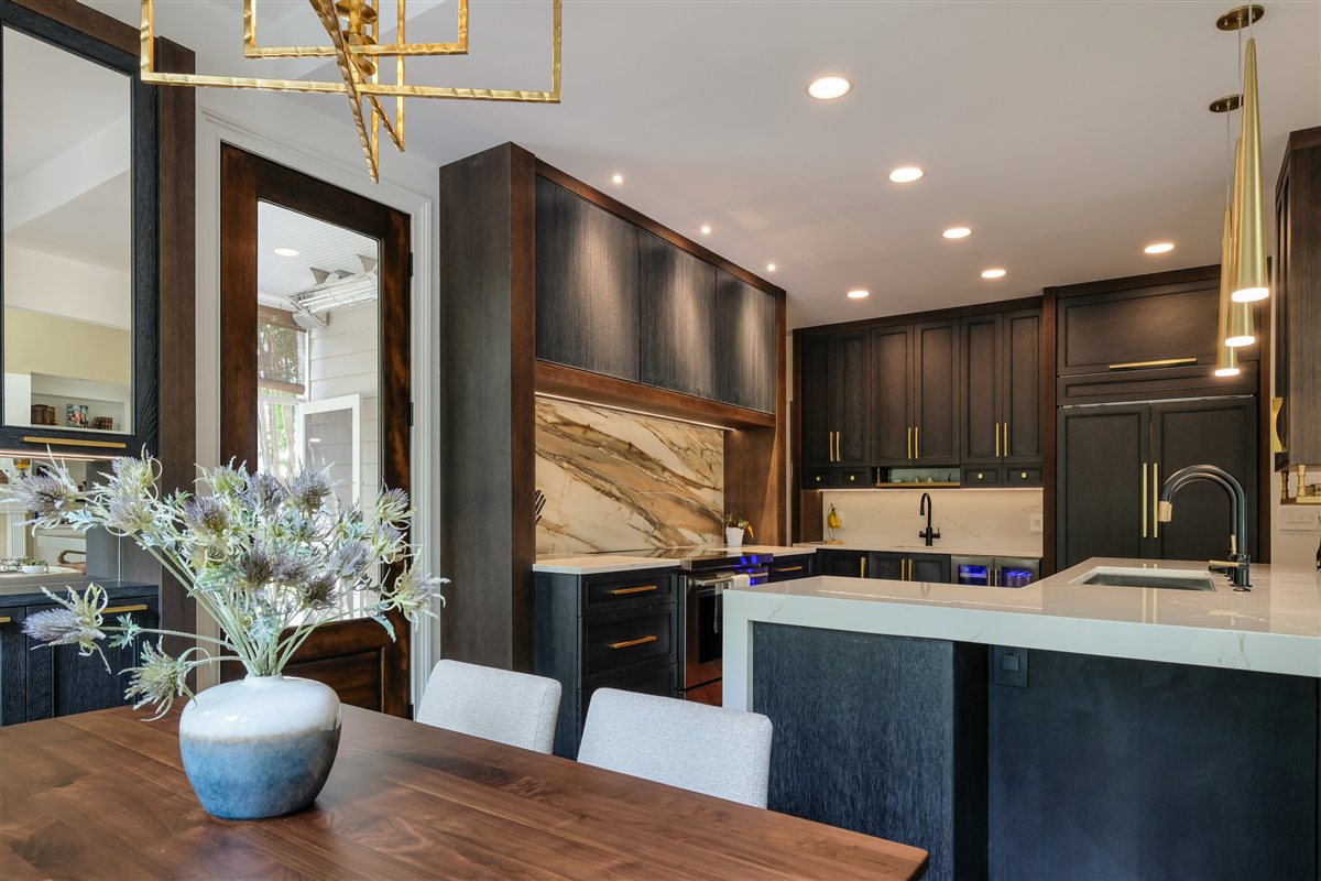 Dining table in the foreground with the kitchen and porcelain slab beyond, Charlotte chef's kitchen