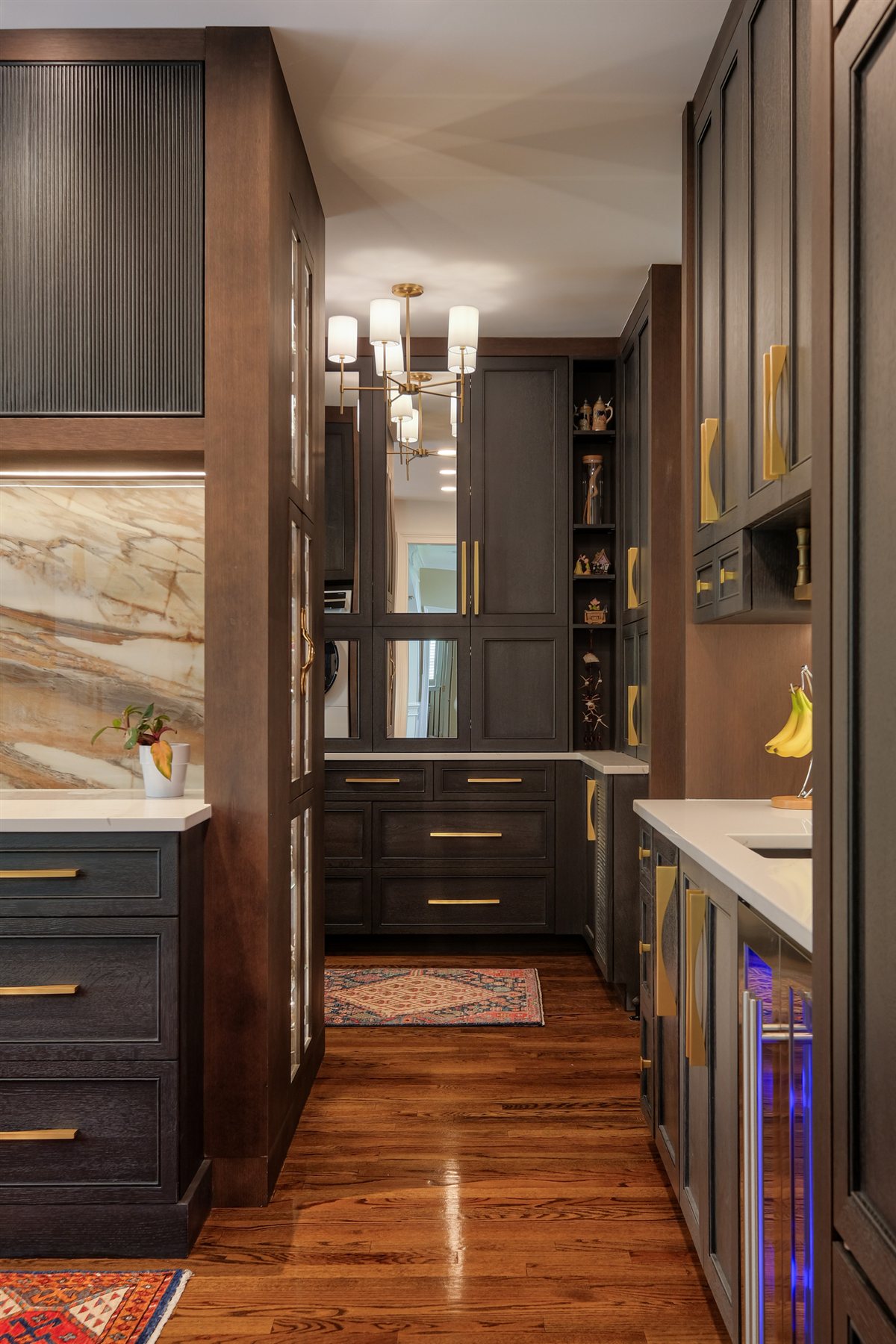 Narrow view of dark cabinetry with a porcelain slab and wine fridge, Charlotte chef's kitchen