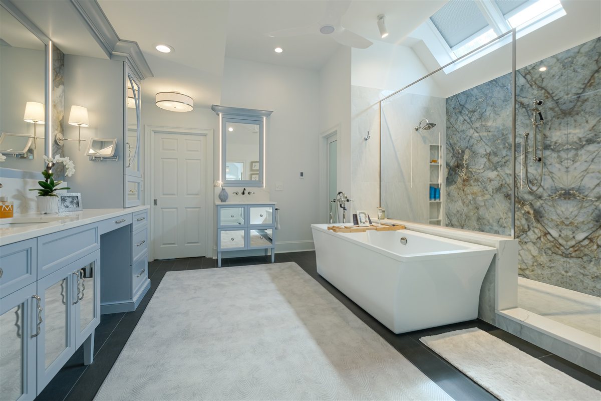 Spa primary bath with a freestanding tub, book-matched porcelain slab shower wall and custom inset vanities, Charlotte primary bath renovation