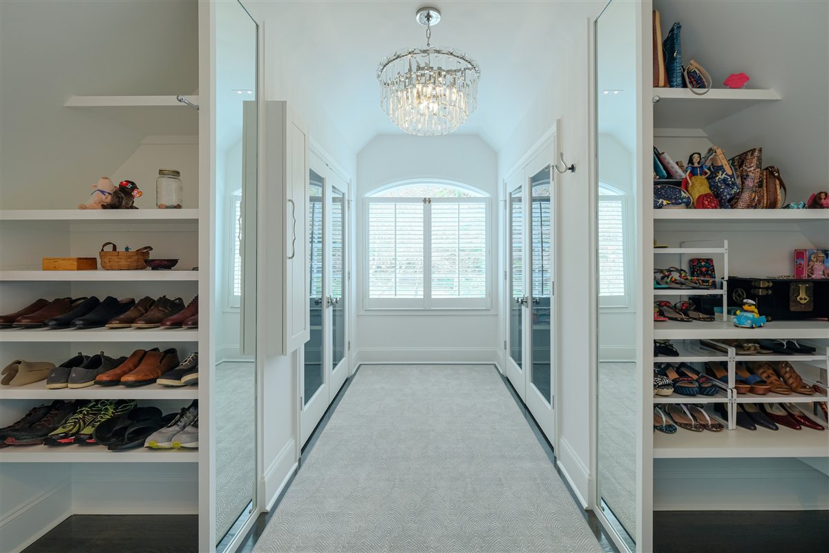 Walk-in closet with shoe shelving and a chandelier, Charlotte spa bath