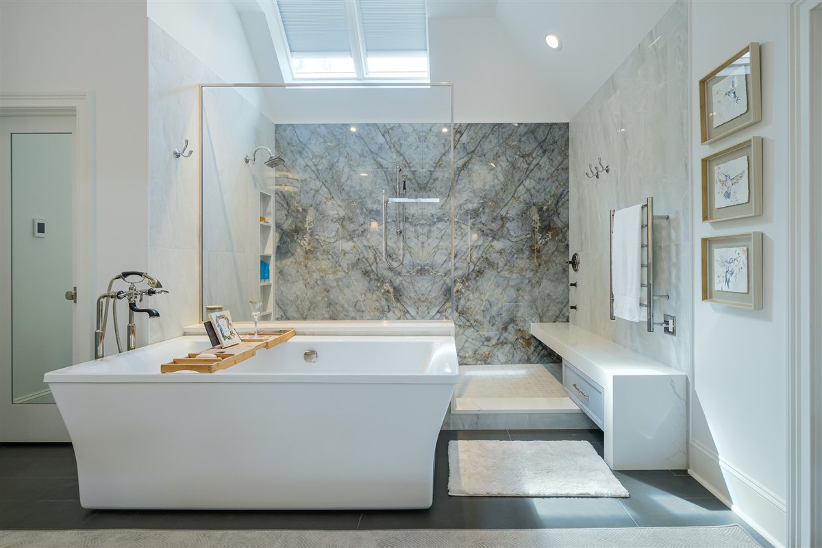 Soaking tub in front of the book-matched porcelain slab shower, Charlotte spa bath