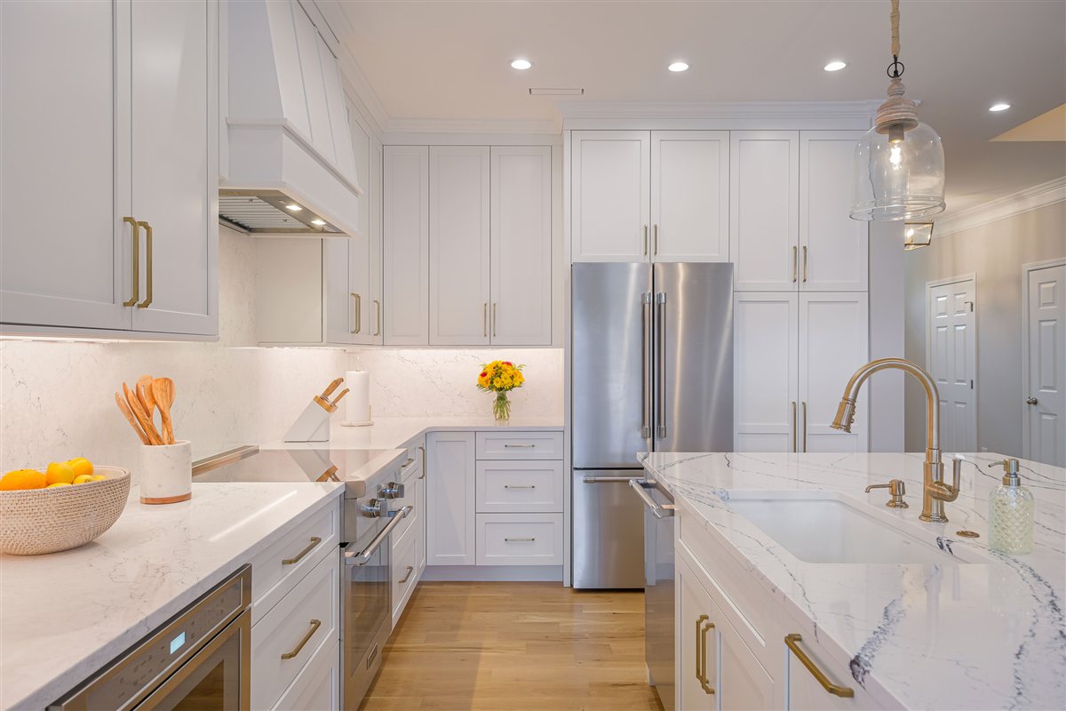 White kitchen with a Cambria quartz island and matching slab backsplash, Peninsula townhouse kitchen