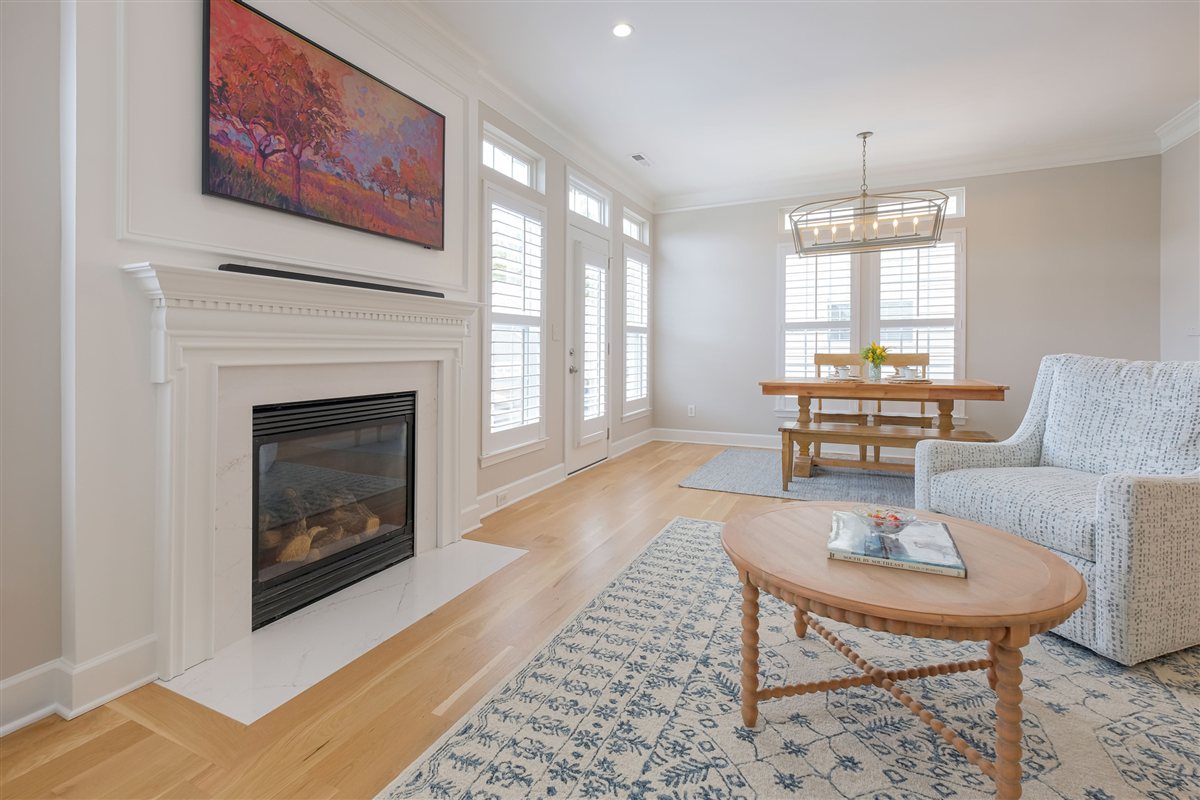 Living room with a quartz-faced fireplace and round coffee table, Peninsula townhouse renovation