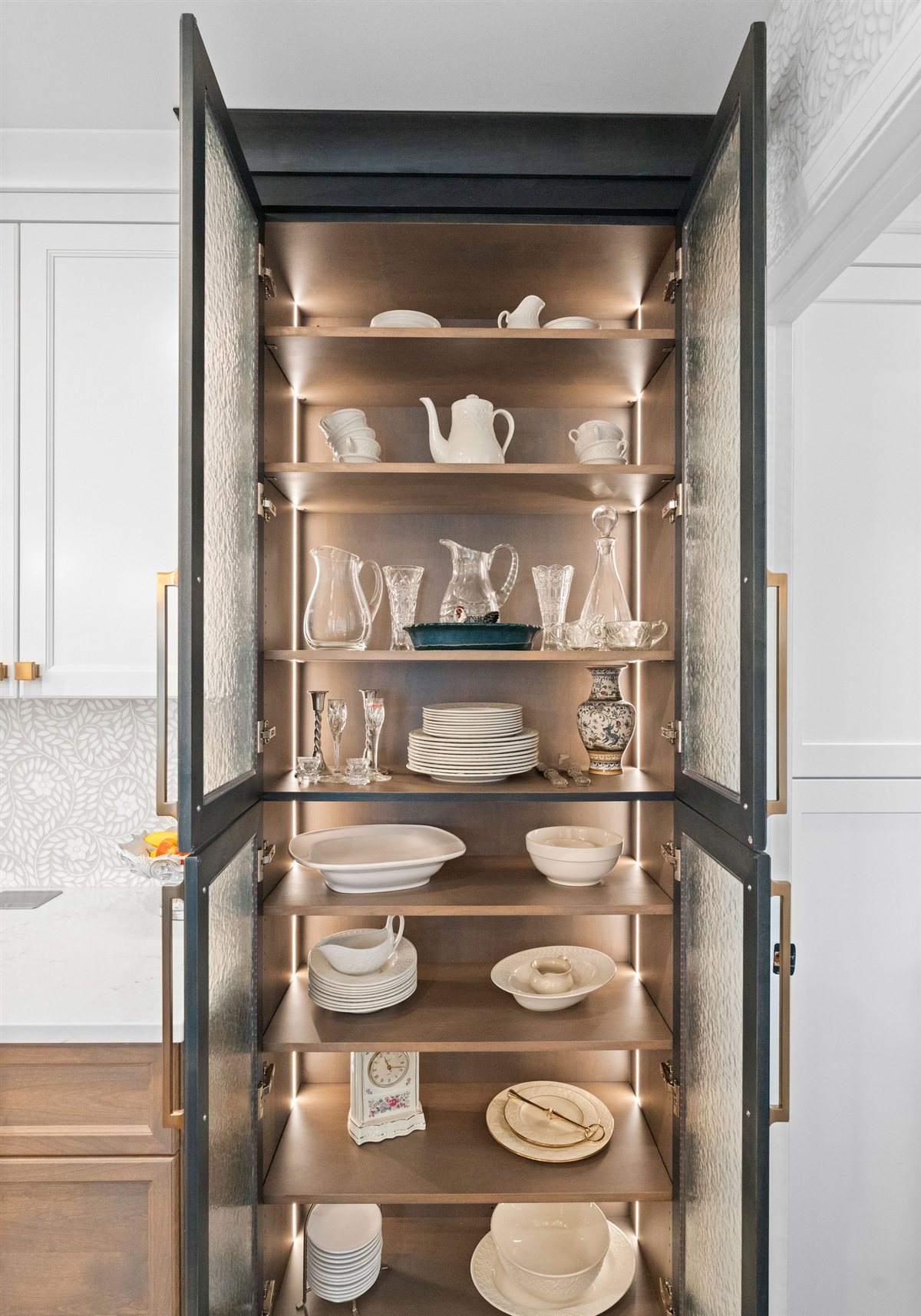 Lit glass display cabinet with a dark frame, River Chase kitchen
