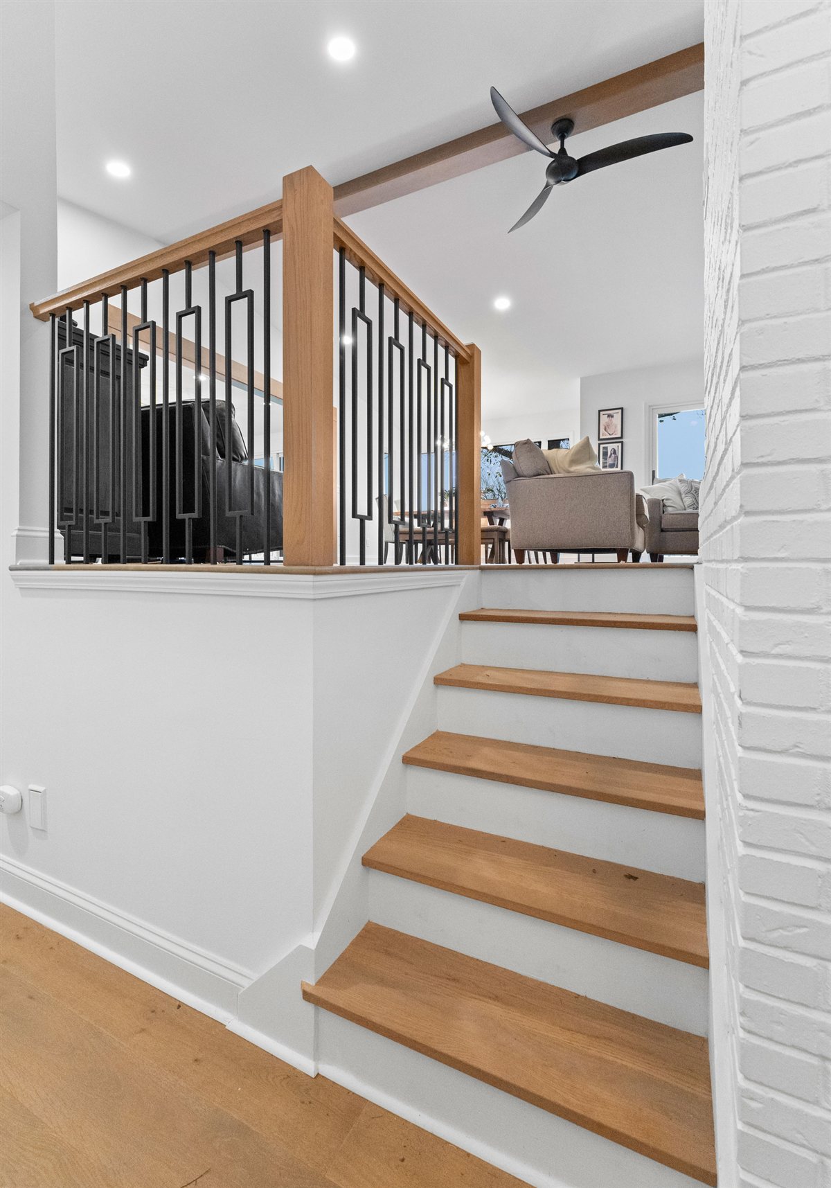 Open stair with oak treads and a black iron railing, River Chase renovation