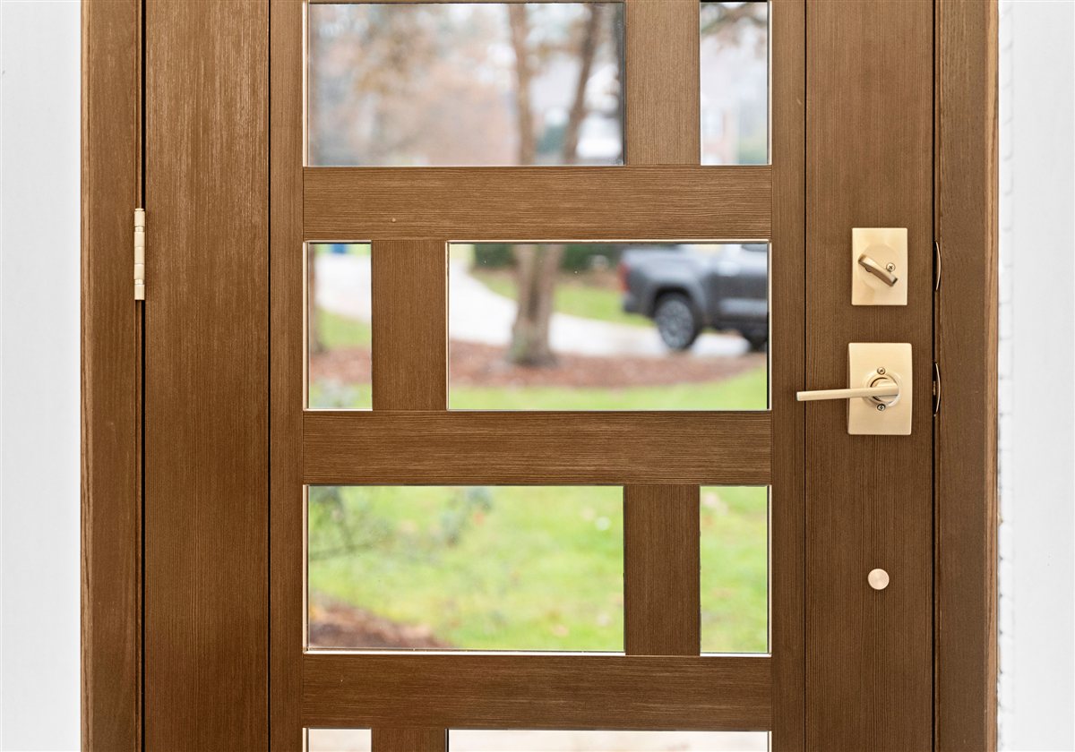 Wood front door with square glass lites and brass hardware, River Chase renovation