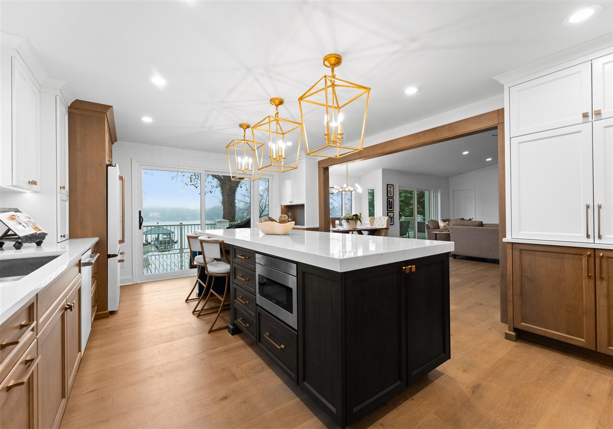 Kitchen island and wood cabinetry with the lake visible through the windows, River Chase renovation