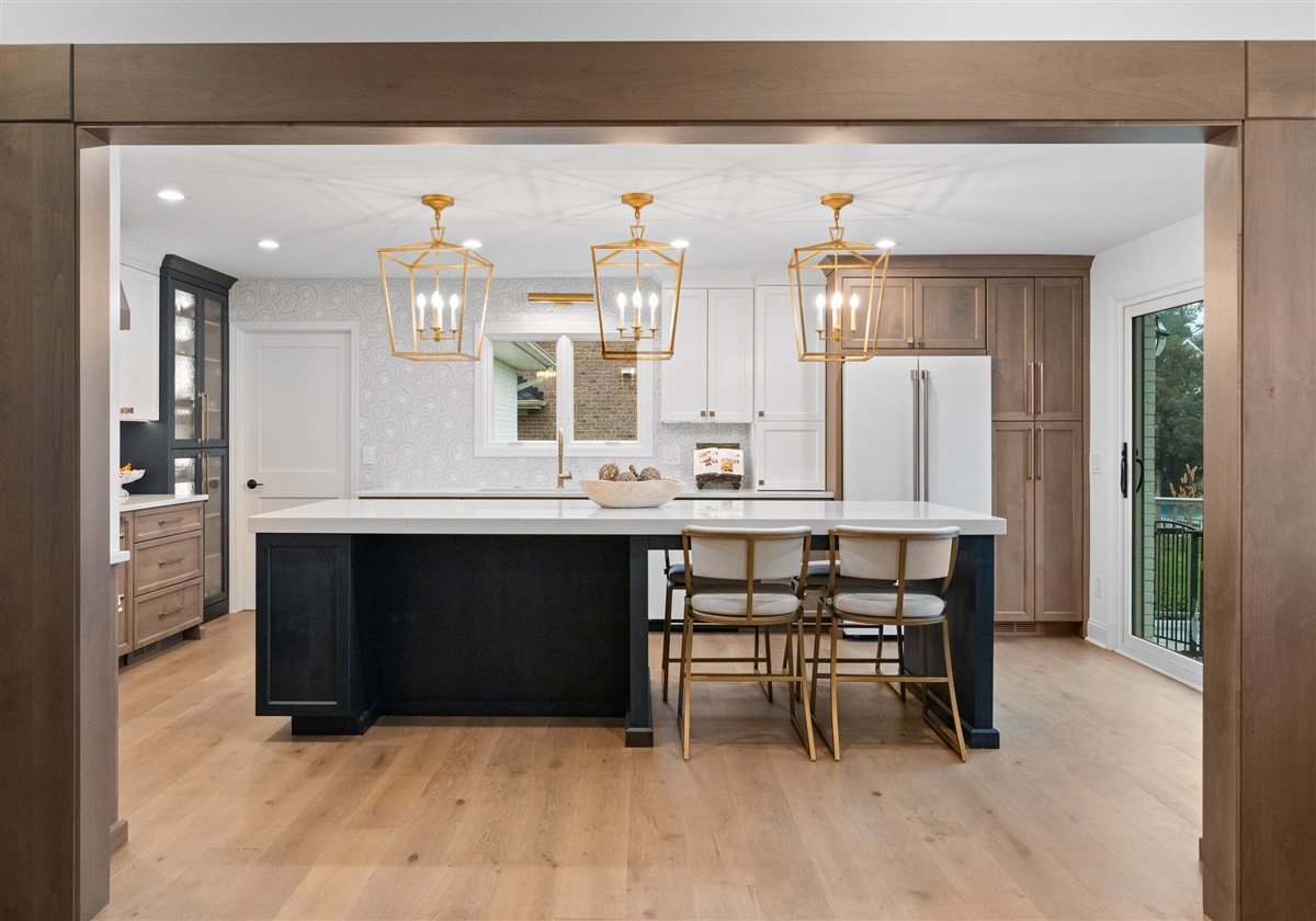 Kitchen framed by a wood-cased opening, River Chase renovation