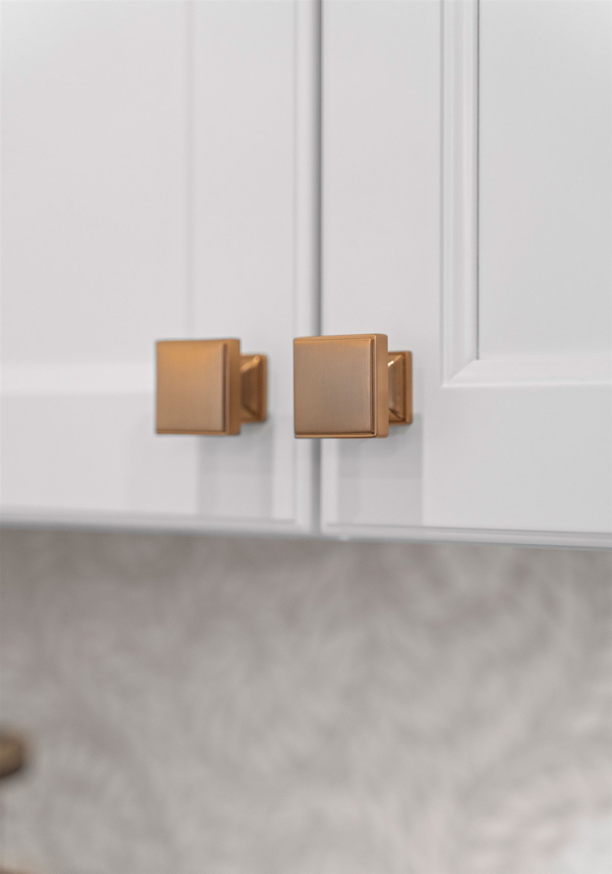 Brass knob hardware on white cabinetry, River Chase kitchen