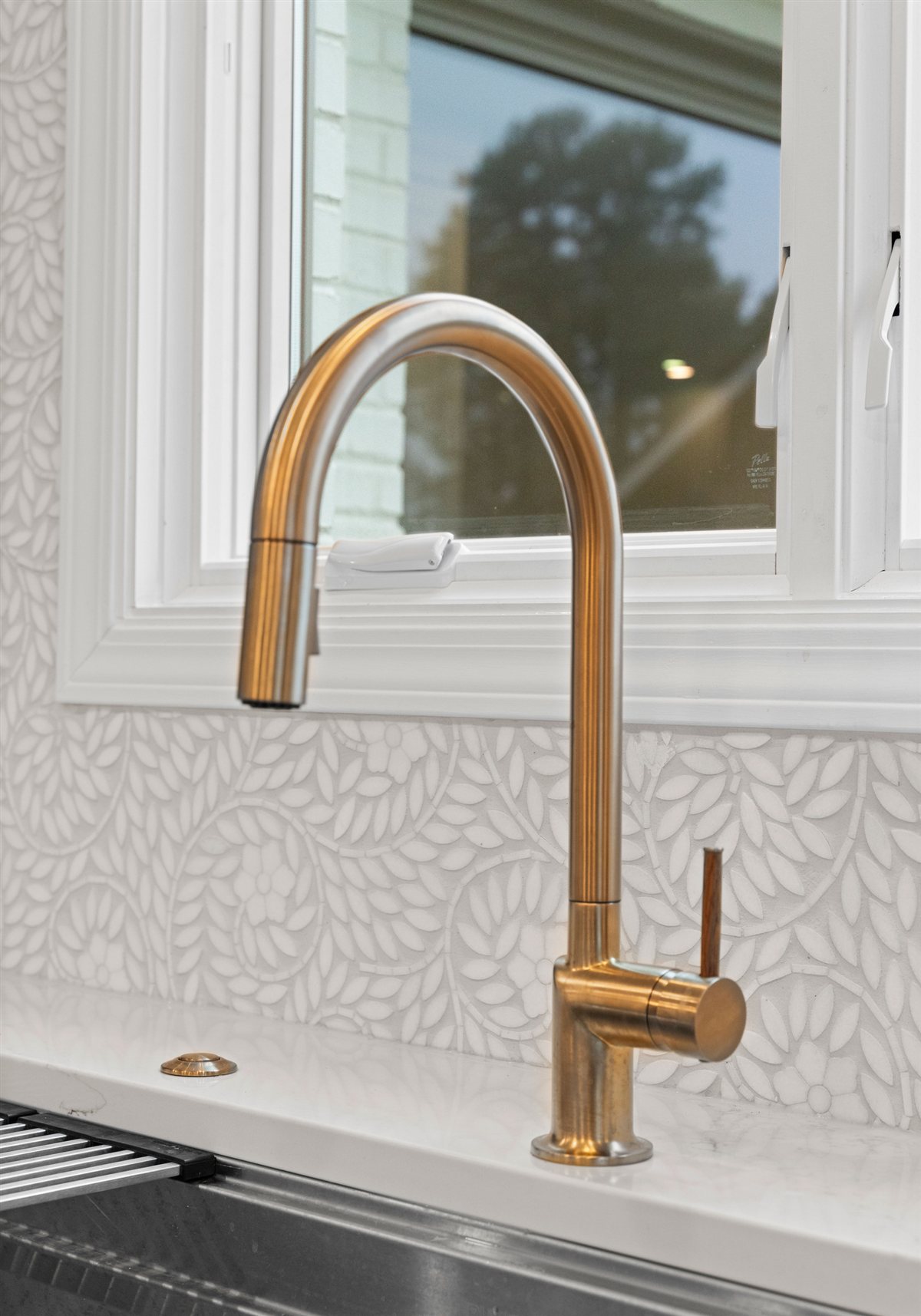 Brass pull-down faucet at the sink, River Chase kitchen