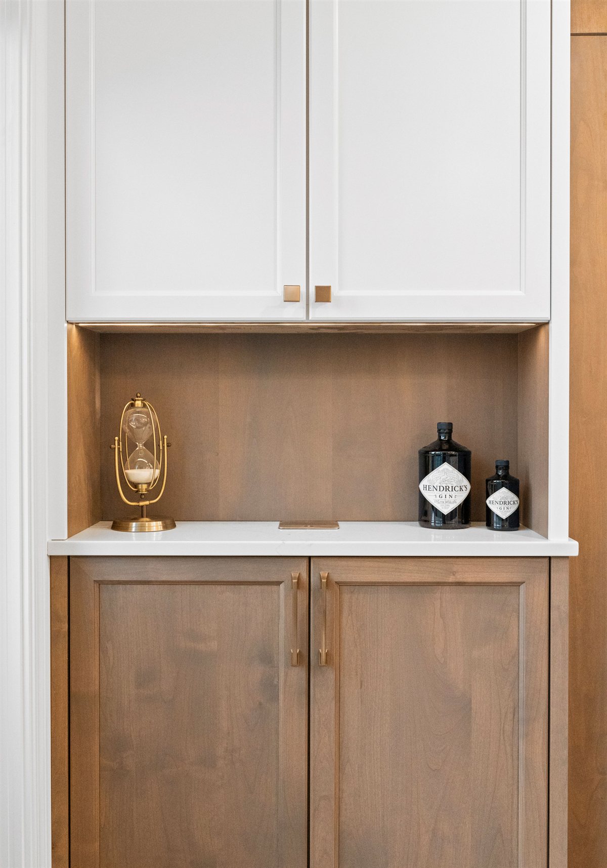 Wood cabinet nook with white upper cabinets and brass hardware, River Chase kitchen