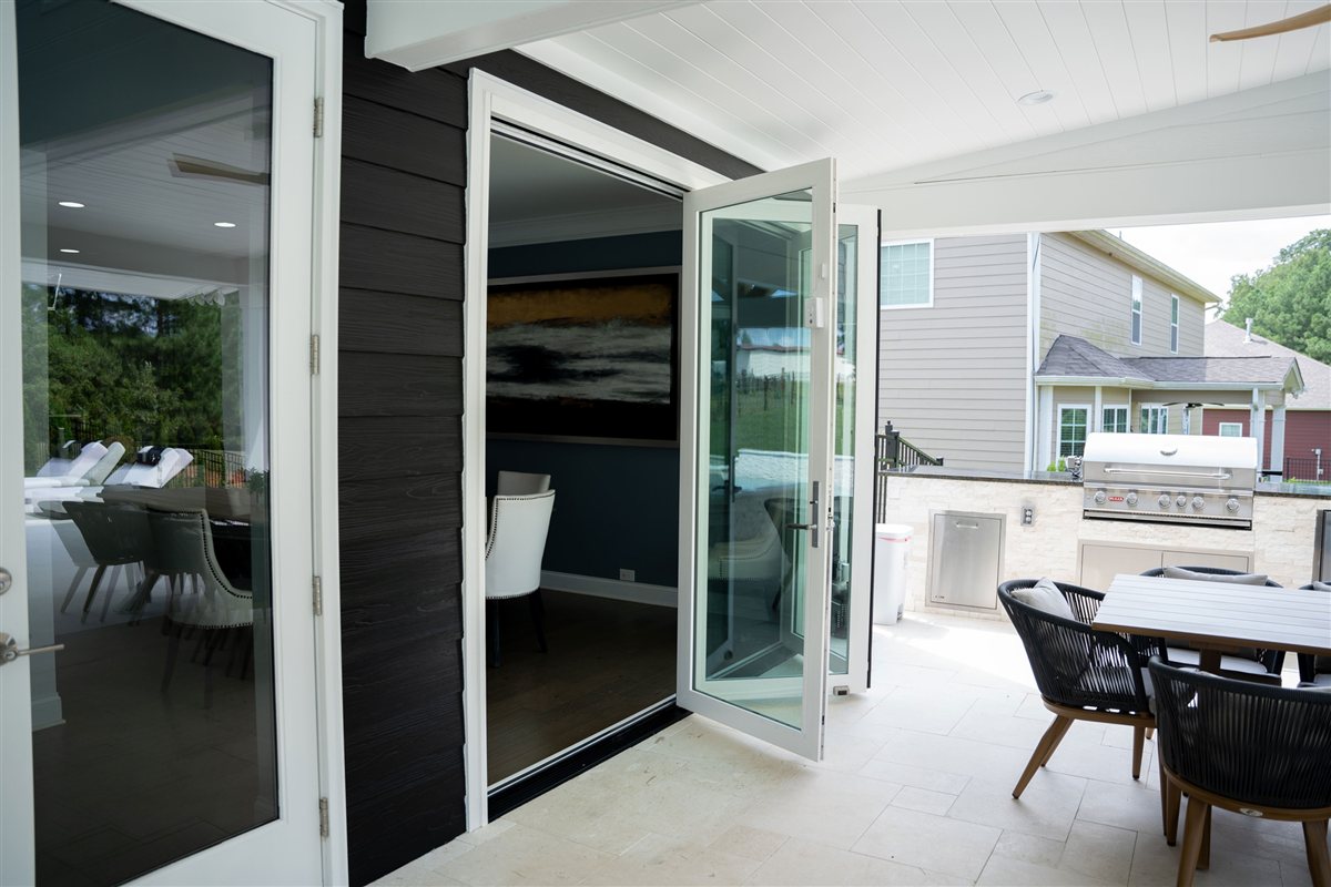 Outdoor dining table beside open folding doors, Denver outdoor living