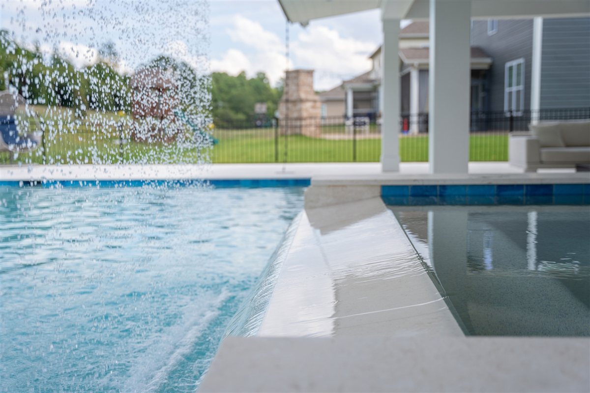 Spa spilling into the pool with a rain curtain behind, Denver outdoor living