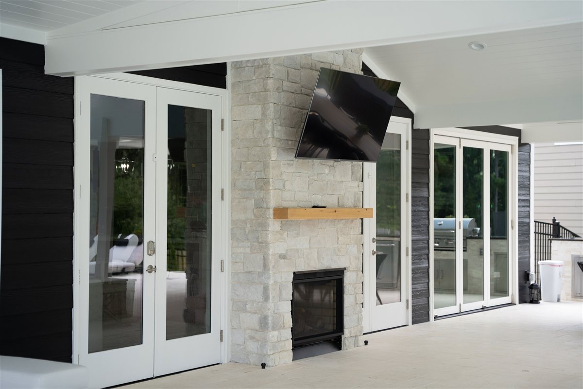 Stone fireplace with French doors and a wood mantel, Denver outdoor living
