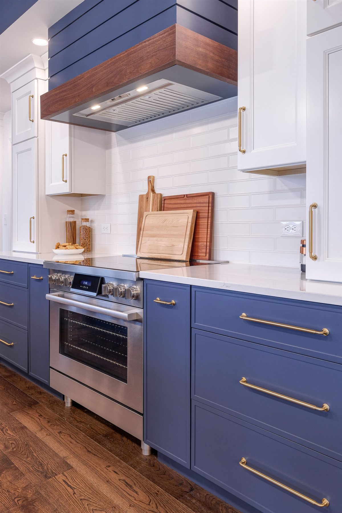 Blue cabinetry with a range and wood hood, Moss Lake kitchen