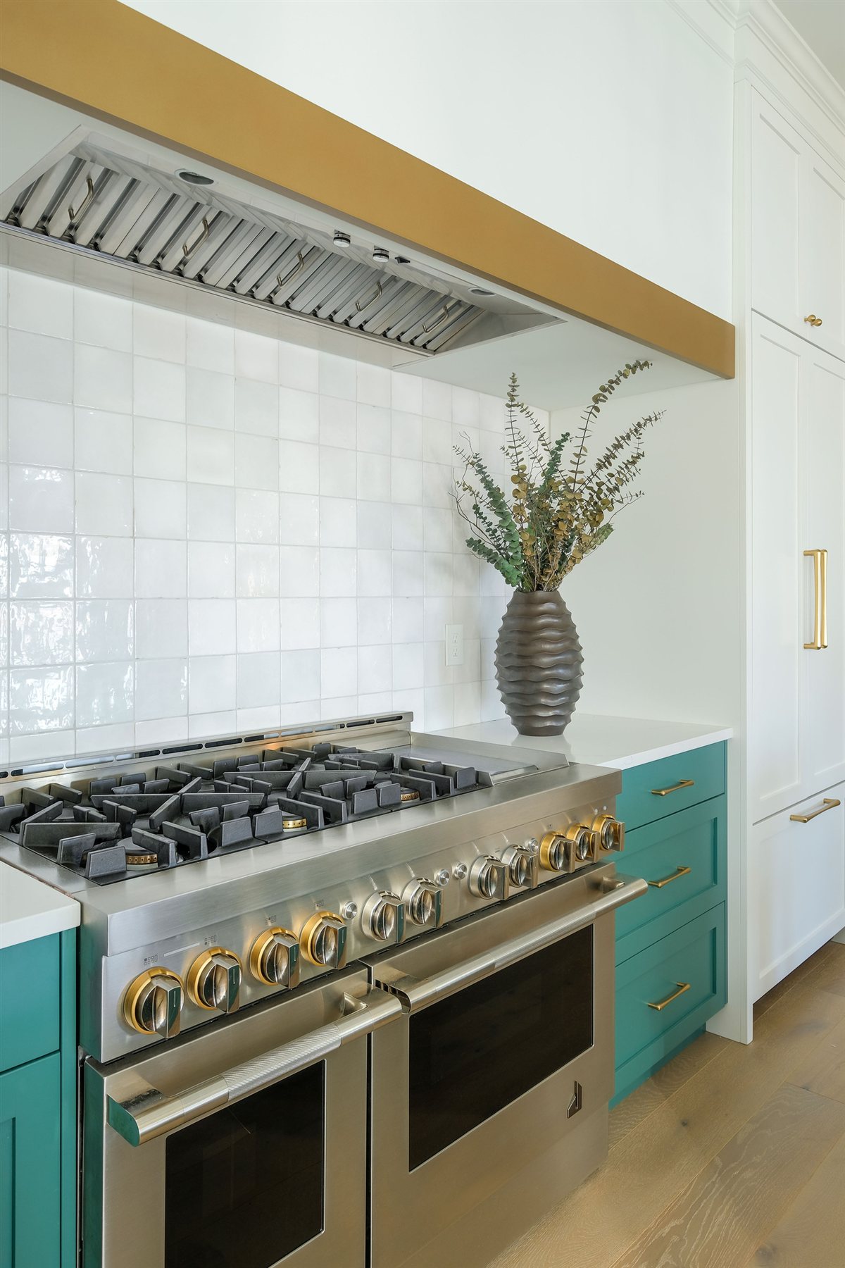 Professional range beneath a stainless hood with brass trim, Lake Wylie kitchen