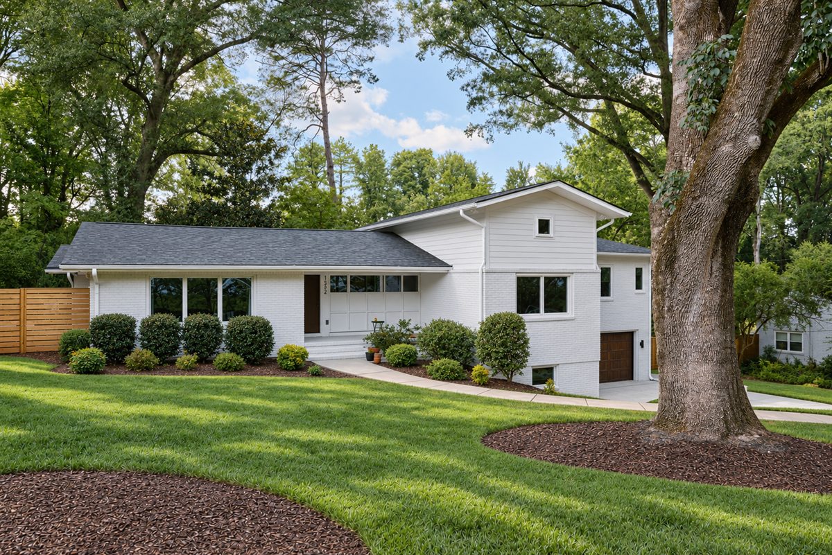 Renovated 1953 house and new addition seen from the front yard under old oaks, Lansdowne, Charlotte