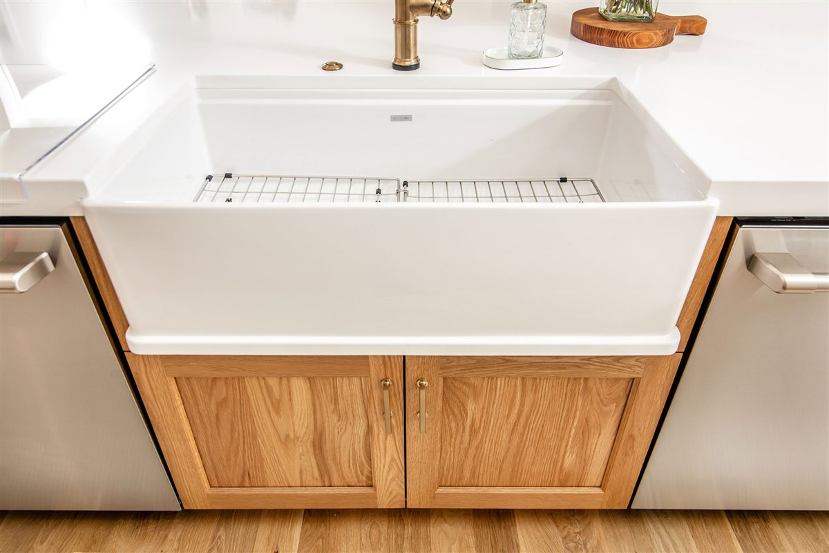 White farmhouse sink set into wood cabinetry, Monroe kitchen
