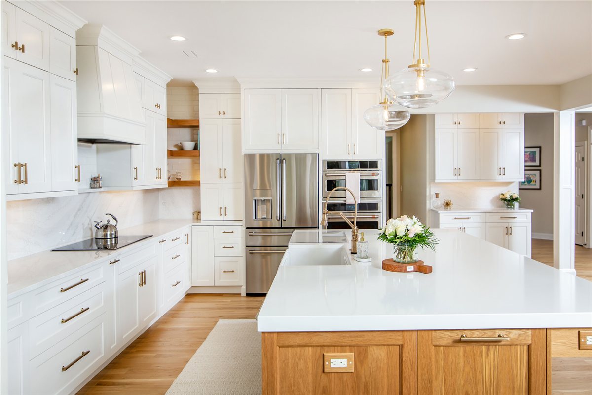 White island and cabinetry beneath a vent hood, Monroe kitchen