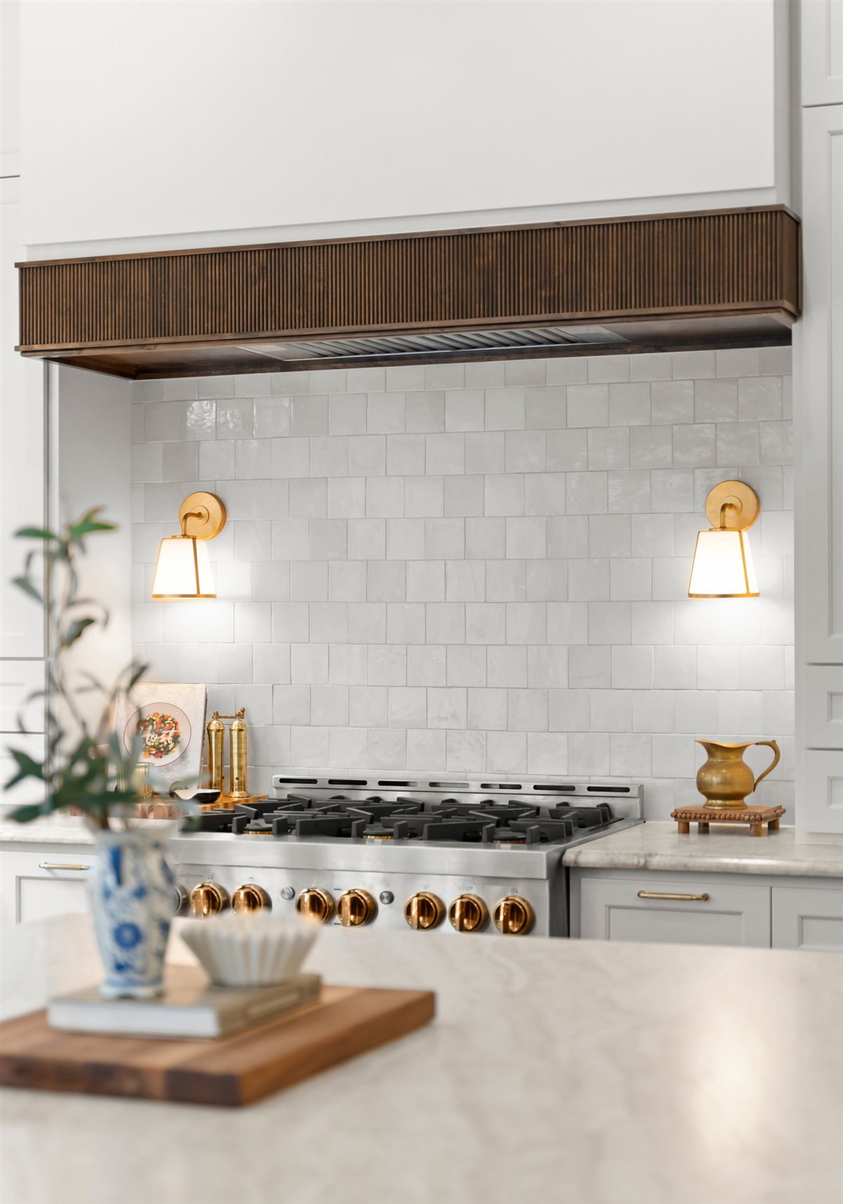 Wood range hood above a white tile backsplash, The Point kitchen