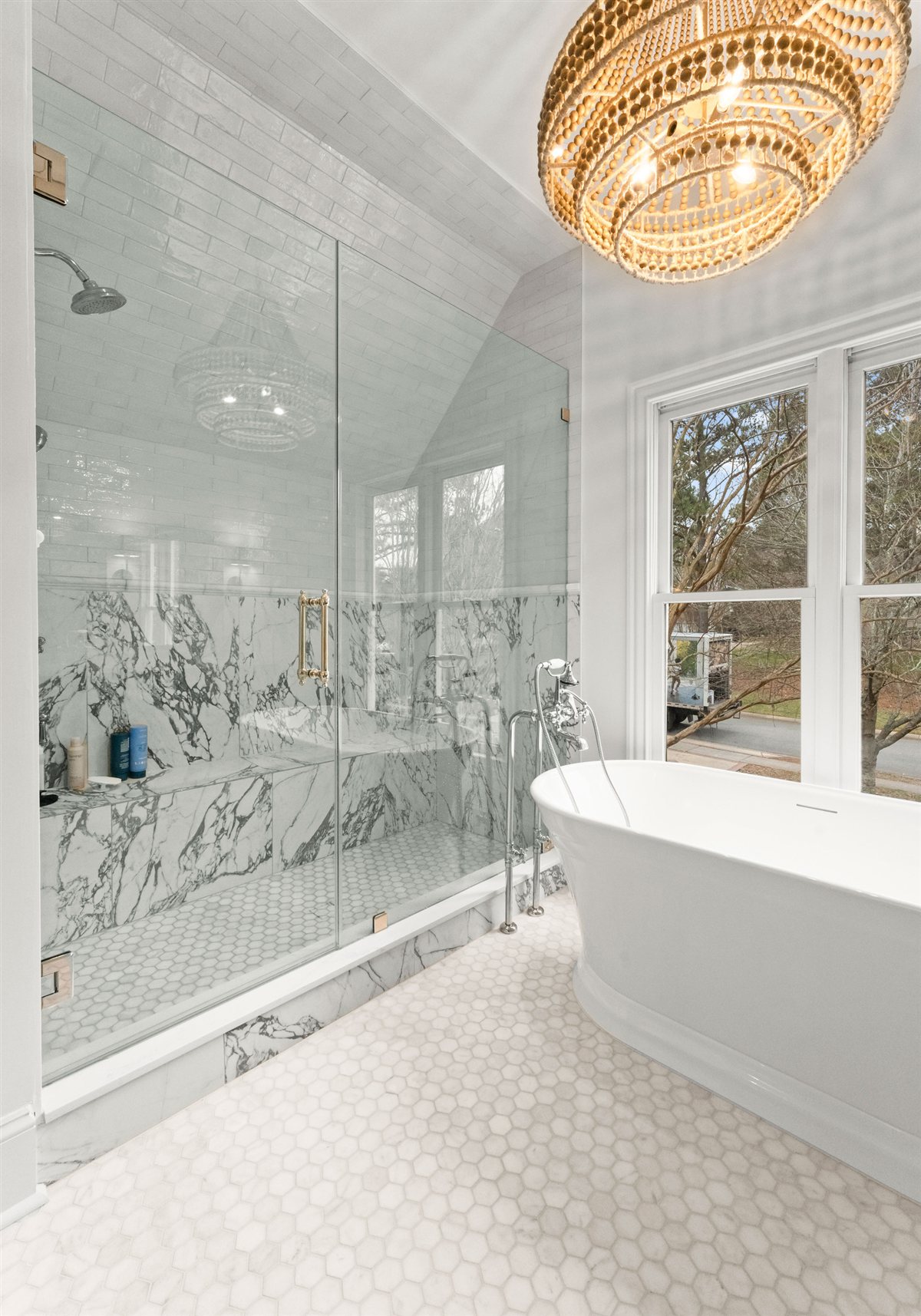 Glass shower and freestanding tub with marble walls, The Point renovation