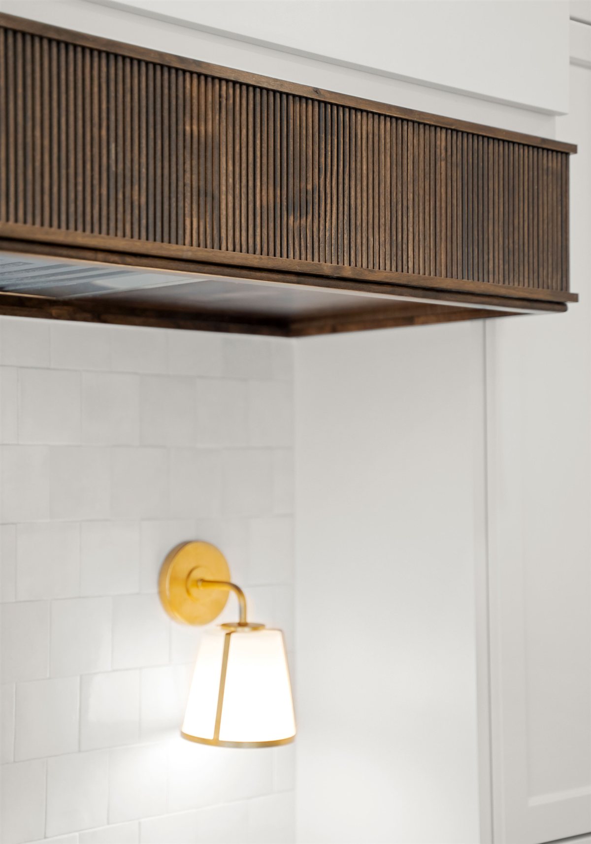 Brass sconce beneath the wood range hood, The Point kitchen