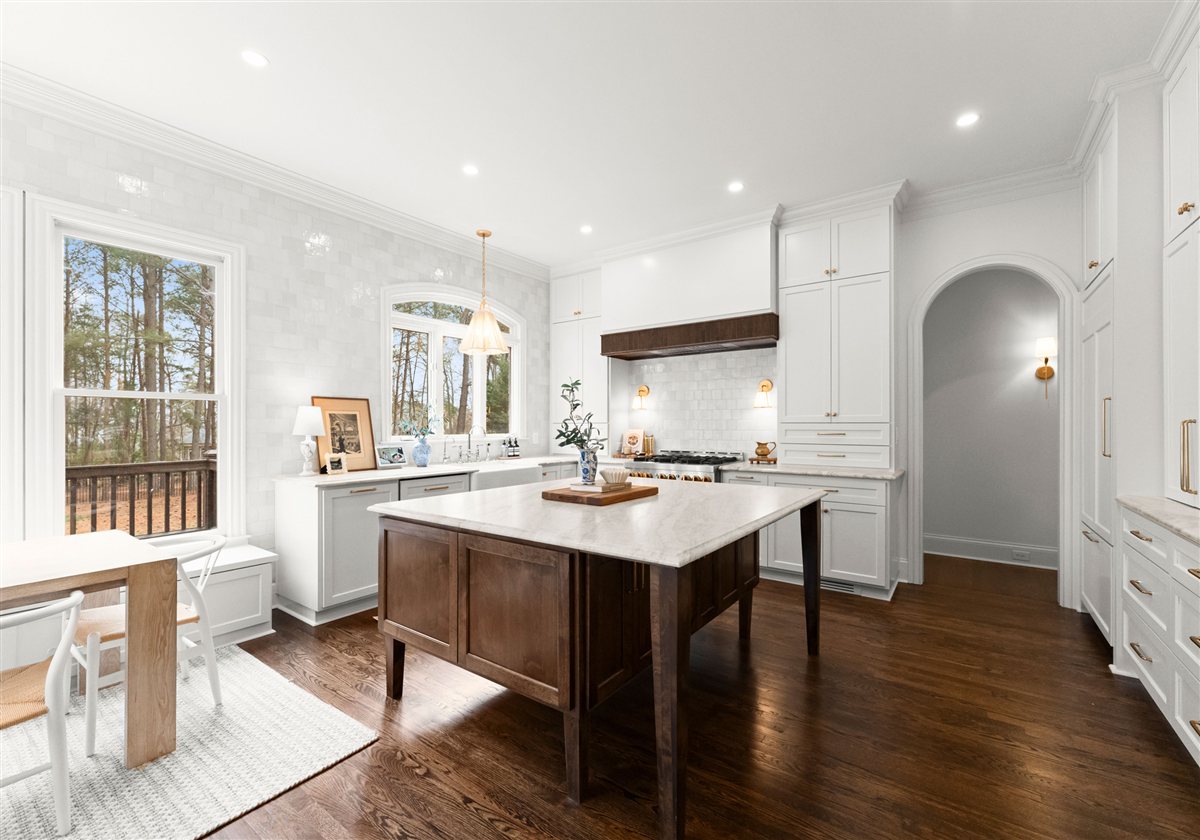 Kitchen with a dark wood island and a window over the dining table, The Point renovation