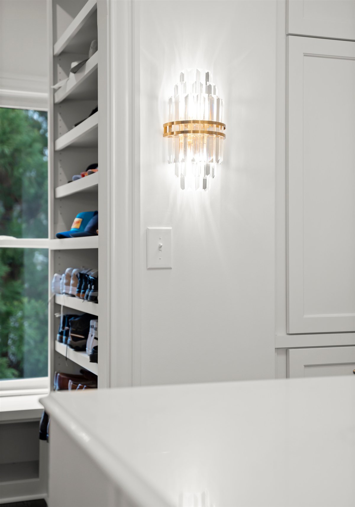 Brass wall sconce beside white cabinetry, The Point renovation