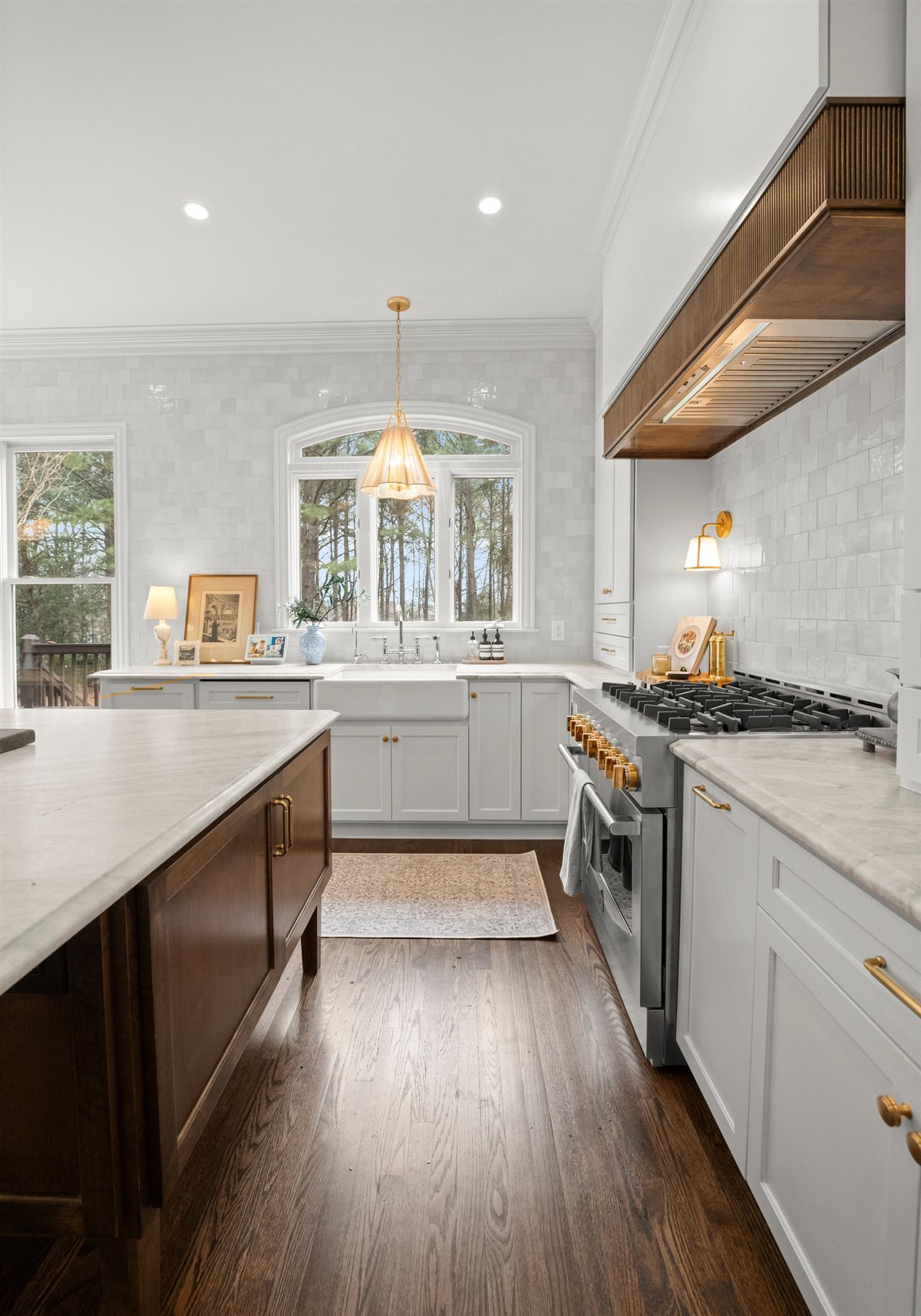 Kitchen with a wood range hood and dark wood island, The Point renovation
