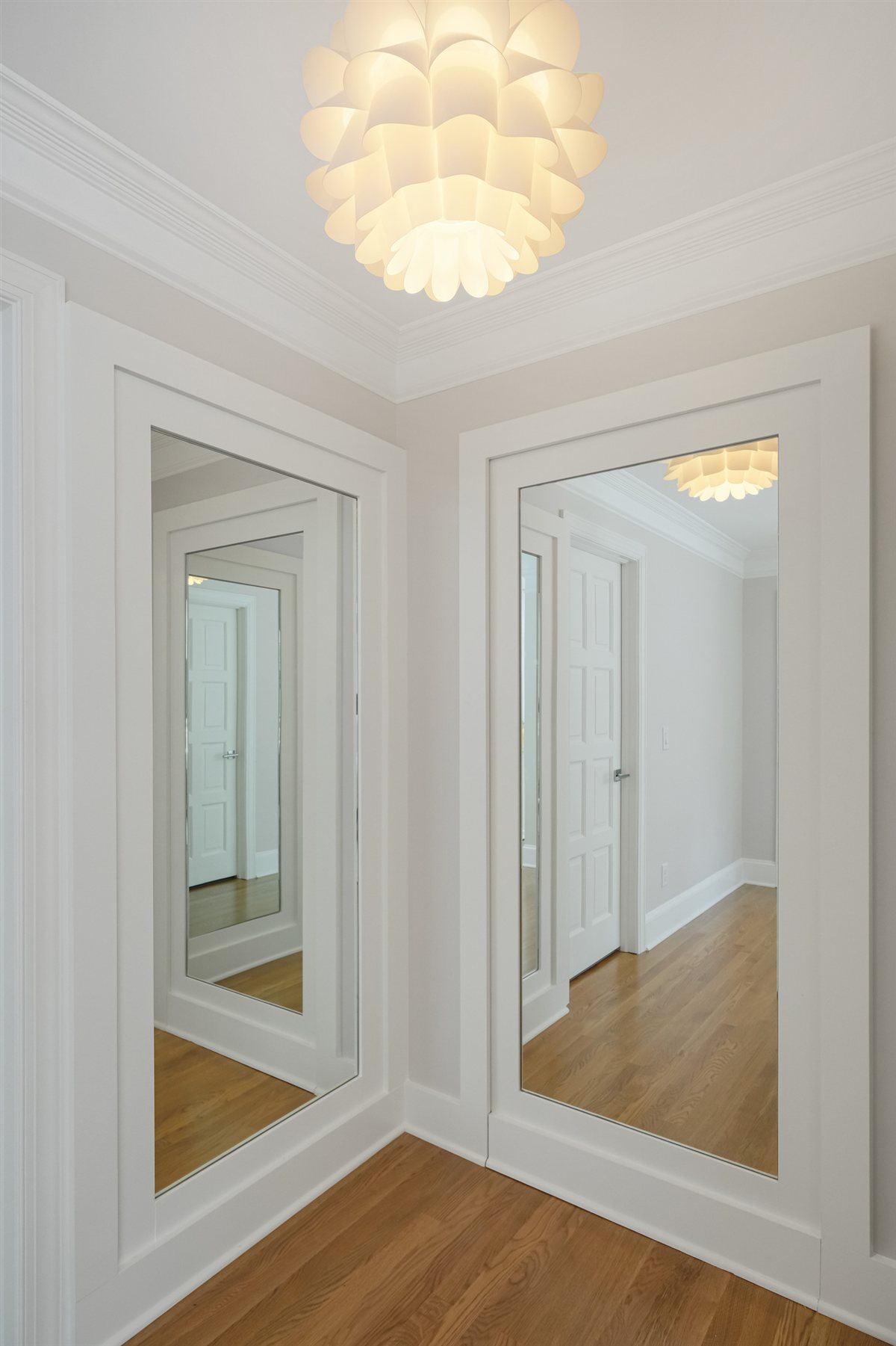 Hallway with mirrored closet doors and a pendant light, Pellyn Wood renovation