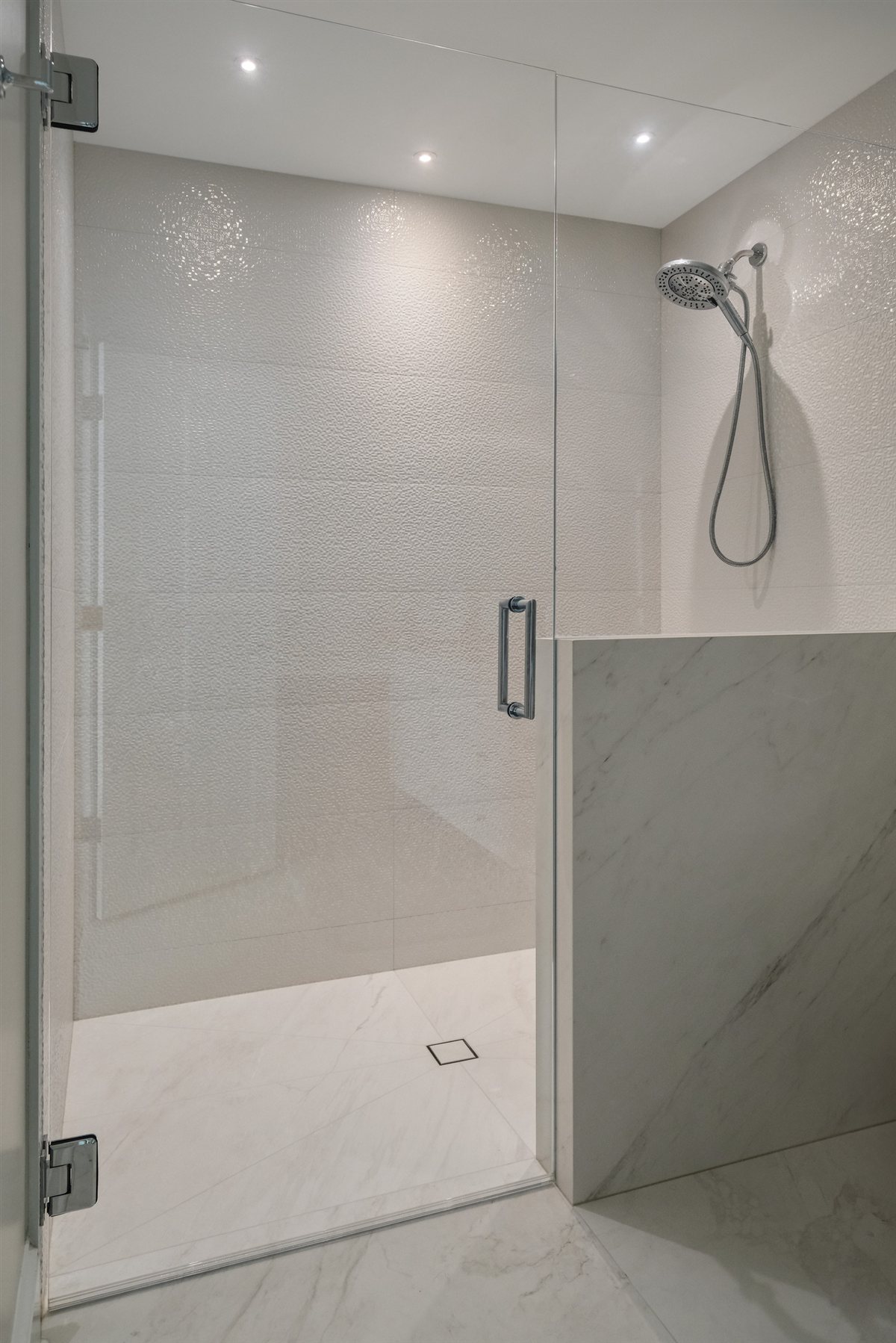 Walk-in shower with white tile and a glass door, Pellyn Wood renovation