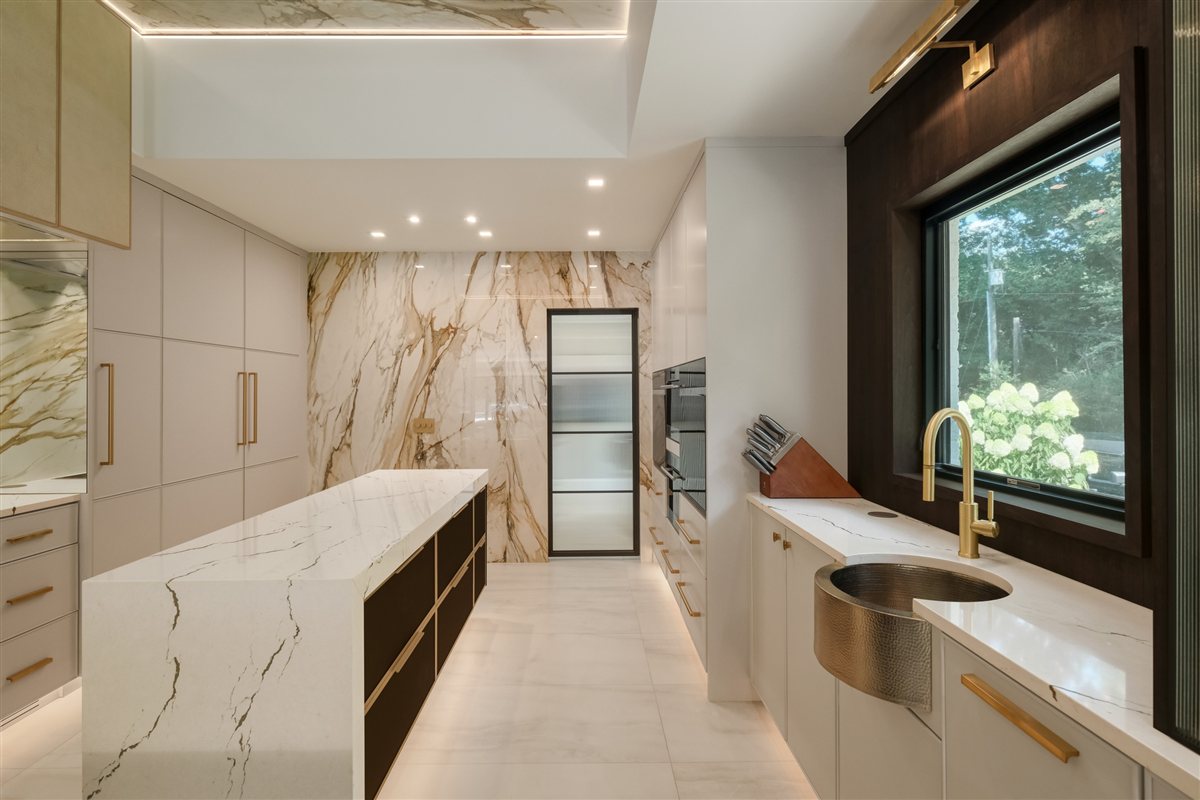 Porcelain slab kitchen with a black-framed window over the sink, Pellyn Wood renovation